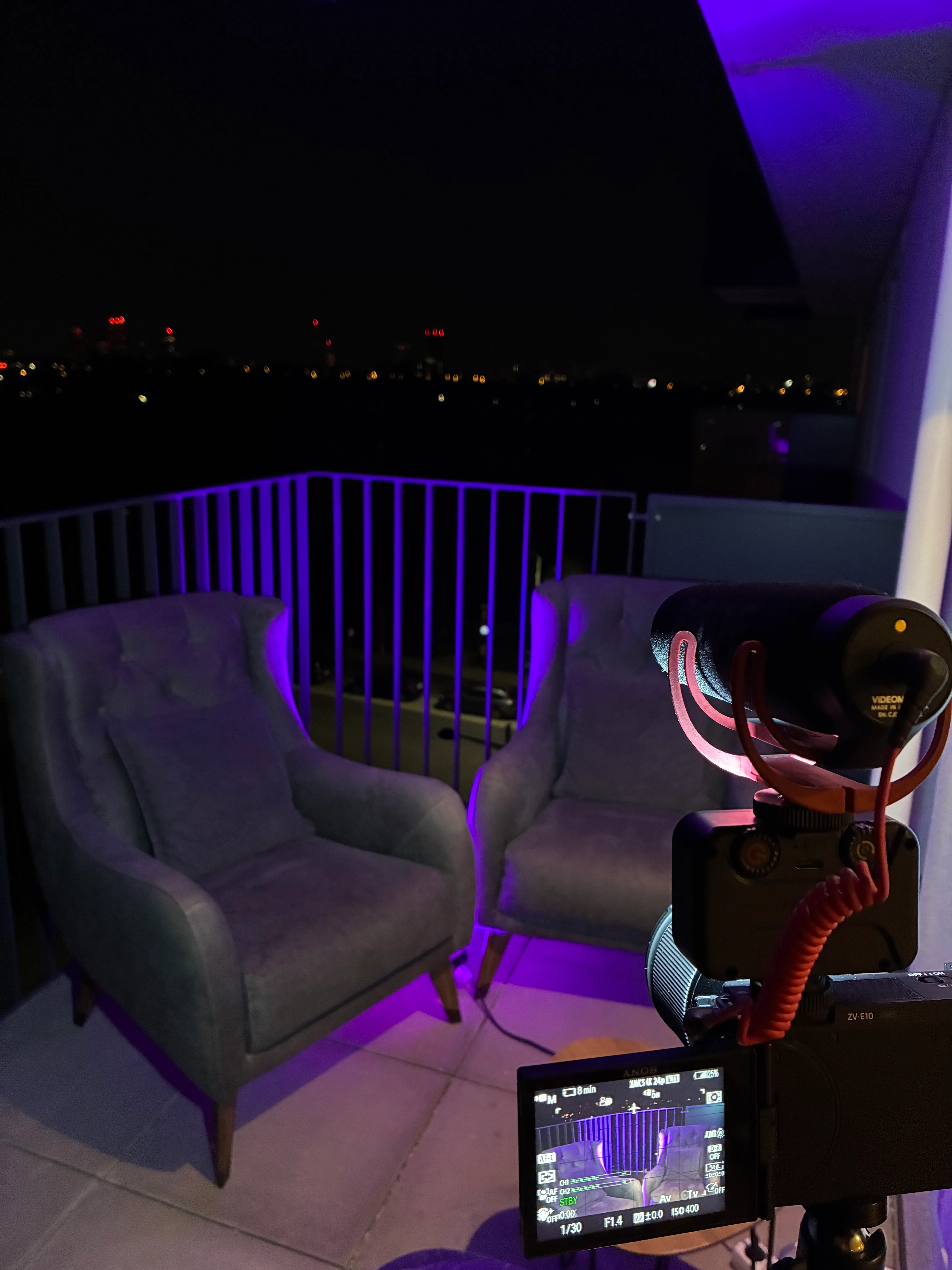 Zwei Samtsessel auf einem Balkon über Wien bei Nacht
